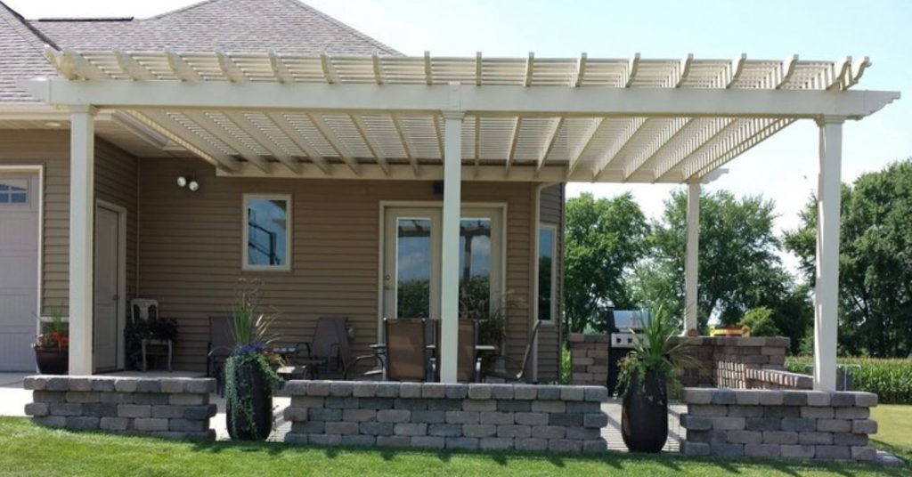 white custom built pergola attached to the back of a home over a porch area